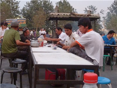 広場で羊肉串を食べる人たち